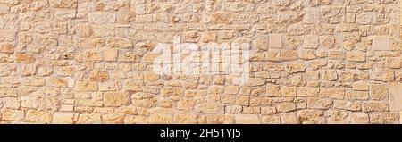 Natürliche breite Panorama-Wand-Design-Muster Hintergrund mit rustikalen rauhen warmen Sandstein Textur Stockfoto