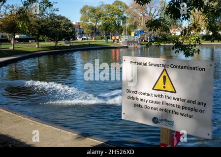 Southchurch Park, Southend on Sea, Essex, Großbritannien. November 2021. Um Southchurch Park Lake herum wurden Warnschilder angebracht, die Besucher davor warnen, dass der direkte Kontakt mit dem Wasser und jeglichen Trümmern Menschen oder Haustieren Krankheiten verursachen und nach der kürzlich aufgetreteten Verunreinigung der Kanalisation nicht ins Wasser gelangen kann. Anglian Water und Southend Borough Council arbeiten daran, die Kontamination zu bewältigen, nachdem die Arbeiten abgeschlossen wurden, um zu verhindern, dass Abwasser in das nahe gelegene Meer geleitet wird. Der See beherbergt verschiedene Wildtiere einschließlich Schwäne Stockfoto