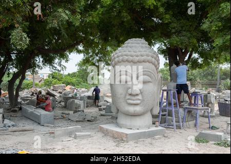 Mamallapuram, Indien - August 2021: Buddhas Kopf wurde in den Stein gemeißelt. Die alte Tradition der Steinbildhauerei ist noch immer in der ganzen Umgebung von Mamallipuram lebendig. Stockfoto