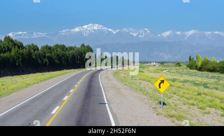 Straßenschild auf gelbem Hintergrund in der Nähe der Autobahn an der Grenze von Mendoza, Argentinien und Santiago de Chile mit schöner Landschaft der Anden Stockfoto