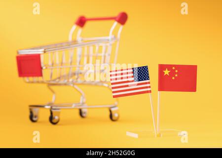 Amerikanische und chinesische Flaggen auf dem Hintergrund eines leeren Lebensmittelkarren, das Konzept des Handels zwischen Ländern Stockfoto