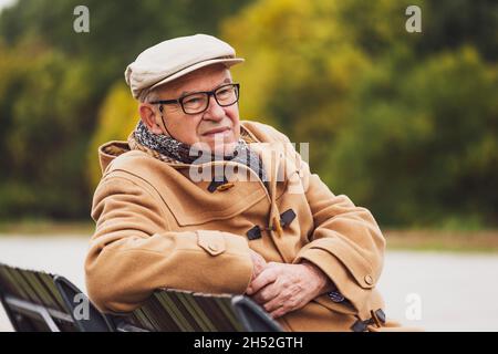 Porträt eines besorgten älteren Mannes im Wintermantel im Freien. Stockfoto
