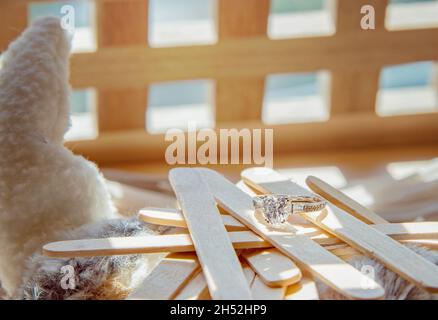 Nahaufnahme des eleganten Diamantrings auf grauem Schal-Hintergrund. Luxus Diamanten Schmuck Accessoire. „I Love You Darling“-Konzept. Stockfoto