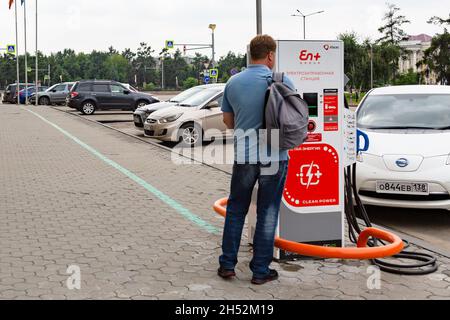 Irkutsk, Russland - am 31. Juli 2021 lädt der Mensch sein Elektroauto. Redaktionell. Stockfoto