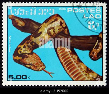 LAOS - UM 1986: Eine in Laos gedruckte Marke zeigt die indische Python, Python molurus, eine große, nicht giftige Python-Art, die in tropischen und subtrop-artigen Pflanzen beheimatet ist Stockfoto