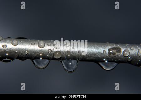 Hängen Sie an einem regnerischen Tag Wassertropfen vom elektrischen Kabeldraht herunter Stockfoto