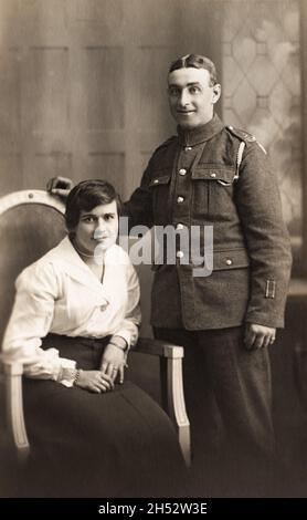 Ein Porträt eines Soldaten und seiner Frau aus der Zeit des Ersten Weltkriegs. Der Mann ist ein Gunner in einer Royal Garrison Artillery-Einheit der Territorial Force. Die zwei Streifen an seinem unteren linken Arm deuten darauf hin, dass er zweimal im aktiven Dienst verletzt wurde. Stockfoto