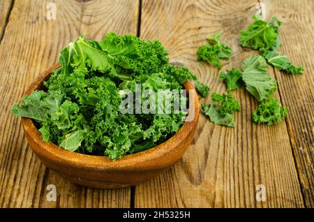 Frische grüne Sabellica-Blätter auf Holzgrund, gesunde Bio-Lebensmittel. Studio Photo Stockfoto