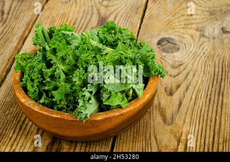 Frische grüne Sabellica-Blätter auf Holzgrund, gesunde Bio-Lebensmittel. Studio Photo Stockfoto