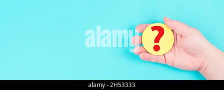 Frau hält ein rotes Fragezeichen in der Hand, blauer Hintergrund, Platz für Text, Antworten finden Stockfoto