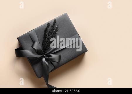 Festliches Geschenk auf der Rückseite, eingewickelt in Papier mit Band auf dem Bienchen-Hintergrund. Speicherplatz kopieren. Nahaufnahme. Geschenk für den Vatertag. Schwarzer Freitag. Stockfoto