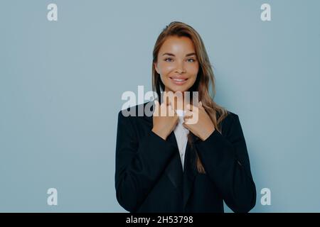 Studioportrait einer jungen erfolgreichen Geschäftsfrau in schwarzem Anzug Stockfoto