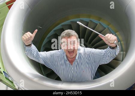 Chief Executive der irischen Fluggesellschaft Ryanair Michael O'Leary, der in einem Jet-Triebwerk auf einer Ryanair Boeing herumwirren wird. Am Flughafen Glasgow Prestwick einen Schraubenschlüssel halten und herumtäuschen Stockfoto
