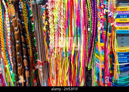 Koper, Slowenien - 12. Juli 2021: Souvenirs für Touristen. Bunte Armbänder. Ein Stand mit kleinen Souvenirs. Stockfoto