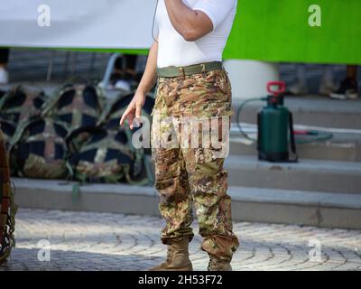 Soldat macht sich bereit für Übungen mit Camouflage Pants und Rucksack auf dem Boden. Stockfoto