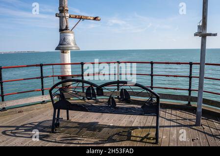 Alte Glocke und Sitzbank am Ende des Southend Pier in der Themse-Mündung mit Blick auf die Nordsee, Großbritannien. Weiter Horizont Stockfoto