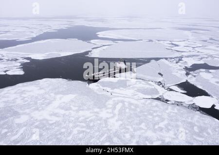 Das Schiff liegt im Meer zwischen dem Eis. Stockfoto