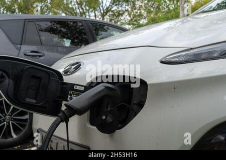 Porreres, Spanien; oktober 31 2021: Nahaufnahme eines weißen Hyundai-Elektroautos an einer elektrischen Ladestelle, an der die Batterie geladen wird. Erneuerbare Energie Stockfoto