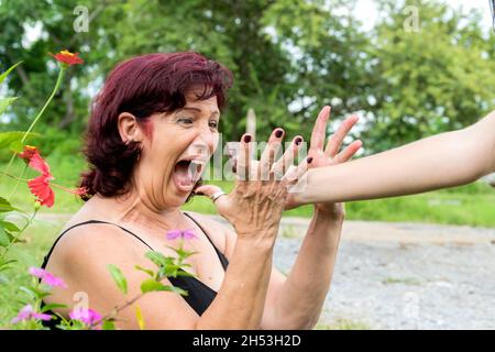 Eine lateinische Erwachsene Frau, die von jemandem, der ihr ein Stück Schokolade anbietet, wirklich überrascht wurde, ist ihr Mund weit offen Stockfoto