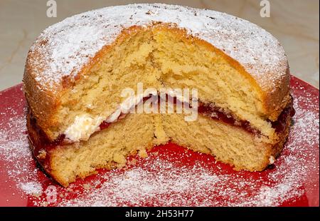 HAUSGEMACHTEN BISKUITKUCHEN MIT FRISCHER CREME UND ERDBEERMARMELADE Stockfoto