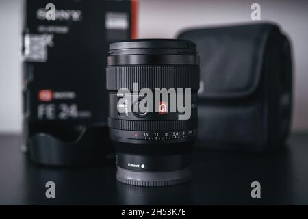 London | UK - 2021.10.09: Nahaufnahme von Produktfotos des Sony FE 24 mm F1.4 GM Objektivs auf schwarzem Schreibtisch Stockfoto