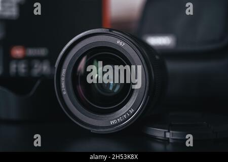 London | UK - 2021.10.09: Nahaufnahme von Produktfotos des Sony FE 24 mm F1.4 GM Objektivs auf schwarzem Schreibtisch Stockfoto
