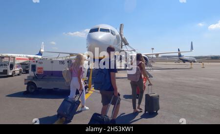 Gudja, Malta Airport, asphaltierte Passagiere vor einem Ryanair-Flugzeug. Reisende mit Masken, die Gepäck auf dem Vorfeld des internationalen MLA-Flughafens transportieren und an Bord eines Boing 737 gehen. Stockfoto