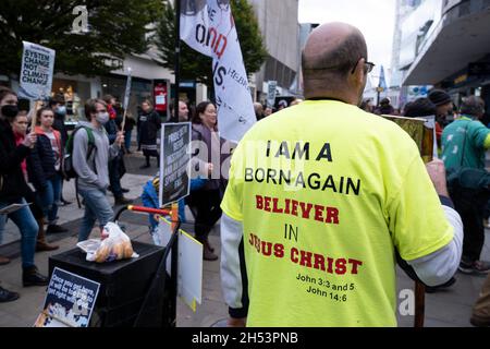 Wiedergeboren ruft der christliche Straßenprediger den Protestierenden zu, dass der Planet ohne Gott nicht gerettet werden kann, während sich die Demonstranten am 6. November 2021 in Birmingham, Großbritannien, für die Unterstützung und den Schutz der biologischen Vielfalt beim ‘Global Day of Action’-marsch der COP26 Coalition und bei der Kundgebung für Klimagerechtigkeit versammeln. Während sich die Staats- und Regierungschefs zur Klimakonferenz der Vereinten Nationen versammeln, marschierten Menschen in Städten auf der ganzen Welt für starke, dringende Maßnahmen, die gegen Natur und Klima ergriffen werden müssen. Der Protest hat das Ziel, unsere Landschaften und unsere wilden ‘zu schützen, wiederherzustellen und effektiv zu verwalten Stockfoto