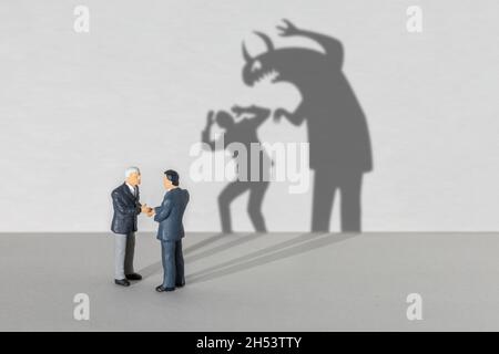 Business Partner Monster. Geschäftsleute schütteln die Hände, aber der Schatten zeigt, dass ein Monster. Stockfoto