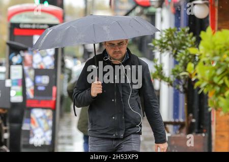 London, Großbritannien. November 2021. Während eines Regenfalls in London untersteht ein Mann unter einem Regenschirm. (Bild: © Dinendra Haria/SOPA Images via ZUMA Press Wire) Stockfoto