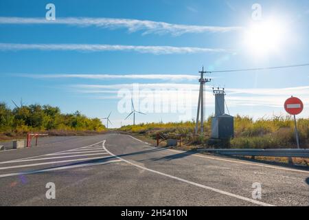 Windturbinen im offenen Gelände an windigen Tagen mit dunklen Wolken am Himmel. Alternative Stromerzeugung. Stockfoto