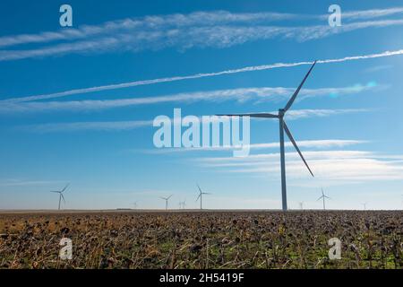 Windturbinen im offenen Gelände an windigen Tagen mit dunklen Wolken am Himmel. Alternative Stromerzeugung. Stockfoto