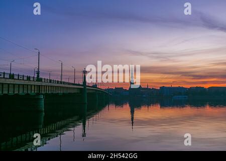 Der Sonnenaufgang über dem alten Riga spiegelte sich im Spiegel der Daugava wider Stockfoto