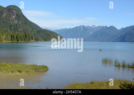 Ein Motorboot auf dem Pitt Lake, einem der größten Gezeitenseen der Welt, und den Bergen der Garibaldi Range, Pitt Meadows, British Columbia, Kanada. Stockfoto