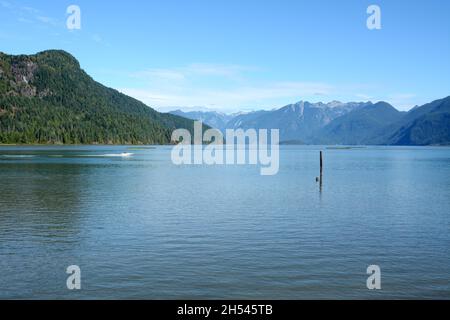 Ein Motorboot auf dem Pitt Lake, einem der größten Gezeitenseen der Welt, und den Bergen der Garibaldi Range, Pitt Meadows, British Columbia, Kanada. Stockfoto