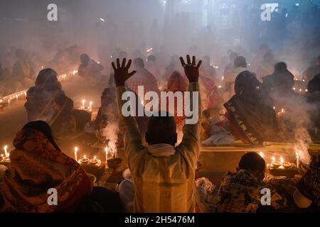 Narayanganj, Bangladesch. November 2021. Ein Anhänger hebt seine Hände, während sie während des Hindu-Fastenfestes im Shri Shri Lokanath Brahmachari-Ashram-Tempel beten.Schüler von Baba Lokenath Brahmachari feierten Rakher Upobash oder kartik broto, indem sie bis zum Abend fasteten und Lampen im Barodi Lokenath-Ashram in Narayanganj anzünden. (Foto von Piyas Biswas/SOPA Images/Sipa USA) Quelle: SIPA USA/Alamy Live News Stockfoto