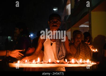 Narayanganj, Bangladesch. November 2021. Ein Mann, der brennende Kerzen hält, betet im Shri Shri Lokanath Brahmachari Ashram Tempel während des Hindu-Fastenfestes.Schüler von Baba Lokenath Brahmachari feierten Rakher Upobash oder kartik broto bis zum Abend, indem sie fasteten und Lampen im Barodi Lokenath Ashram in Narayanganj anzündeten. (Foto von Piyas Biswas/SOPA Images/Sipa USA) Quelle: SIPA USA/Alamy Live News Stockfoto