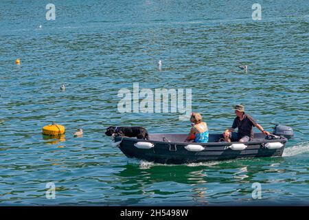 Ein Paar und ihr Hund in einem Schlauchboot auf dem Fluss Fowey, Cornwall, Großbritannien. Stockfoto