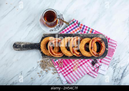 Türkische Bagel Kandil simiti mit Tee (Stapel Gebäck). Ein herzhaftes, ringförmiges kandil simidi-Gebäck, das in der Regel an heiligen Nächten gegessen wird. Stockfoto