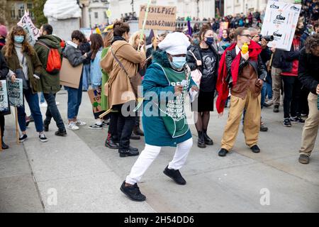 London, Großbritannien. November 2021. Ein Klimaaktivist sah während der Demonstration auf dem Trafalgar Square tanzen. Globale Bewegungen wurden von Klimaaktivisten in mehr als 250 Ländern weltweit aufgerufen, um die Regierungen zu drängen, bei der COP 26 in Glasgow Maßnahmen zur Bekämpfung des Klimawandels zu ergreifen. In London marschierten Aktivisten von der Bank of England zum Trafalgar Square, gefolgt von einer statischen Kundgebung mit Reden von indigenen Kämpfen, Gewerkschaften, Gruppen für Rassenjustiz und Jugendstreikern. Kredit: SOPA Images Limited/Alamy Live Nachrichten Stockfoto