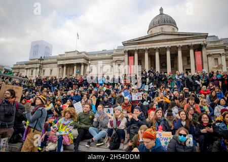 Klimaaktivisten sahen, wie sie während der Demonstration auf dem Trafalgar Square auf Treppen saßen und ihre Meinung auf Plakaten ausdrückten. Globale Bewegungen wurden von Klimaaktivisten in mehr als 250 Ländern weltweit aufgerufen, um die Regierungen zu drängen, bei der COP 26 in Glasgow Maßnahmen zur Bekämpfung des Klimawandels zu ergreifen. In London marschierten Aktivisten von der Bank of England zum Trafalgar Square, gefolgt von einer statischen Kundgebung mit Reden von indigenen Kämpfen, Gewerkschaften, Gruppen für Rassenjustiz und Jugendstreikern. Stockfoto