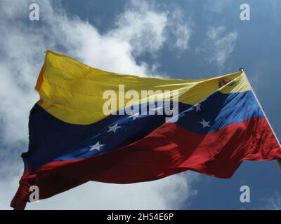 Low-Angle-Aufnahme der Flagge Venezuelas, die im Wind unter dem blauen Himmel weht Stockfoto