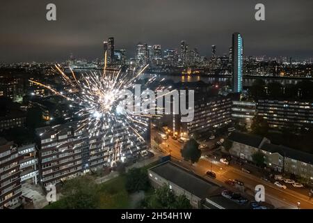 London, Großbritannien. November 2021. Über einem Anwesen im Südosten Londons mit den Gebäuden des Canary Wharf Business Parks wird ein Feuerwerk über Lagerfeuer-Nacht ausgelöst. Kredit: Guy Corbishley/Alamy Live Nachrichten Stockfoto