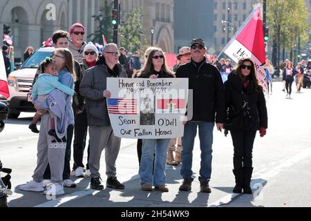 Milwaukee, Wisconsin, USA. November 2021. Die Familie des verstorbenen Sean O'Dell steht an der Parade-Tribüne, um anerkannt zu werden. Nach einem Jahr Pause aufgrund der COVID-Pandemie im Jahr 2020 startete die Veteran's Day Parade, die von der Wisconsin Veterans Chamber of Commerce organisiert wurde, am Samstag, dem 6. November 2021 in der Innenstadt von Milwaukee. Eine Mischung aus Schwimmern, Patriotismus und militärischer Ausrüstung wird von der 5th und Wisconsin Avenue nach Osten Rollen und nach Norden in die Water Street abbiegen. (Bild: © Pat A. Robinson/ZUMA Press Wire) Stockfoto