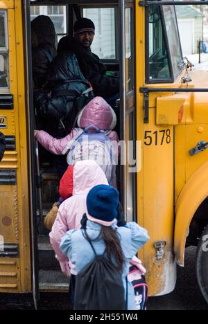 St. Paul, Minnesota. Charterschule für die Hmong. Hmong-Schüler verlassen an einem kalten Tag die Schule, um in den Schulbus zu steigen. Stockfoto