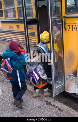 St. Paul, Minnesota. Charterschule für die Hmong. Hmong-Schüler verlassen an einem kalten Tag die Schule, um in den Schulbus zu steigen. Stockfoto