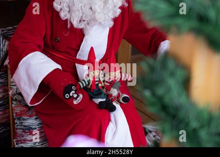 Weihnachtsmann mit Weihnachtsspielzeug, das für Kinder spielt. Weihnachtsstimmung und Weihnachtsunterhaltung für Kinder. Stockfoto