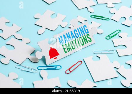 Schild mit der Anzeige „Emotionen managen“. Wort für Fähigkeit sei offen für Gefühle und moduliere sie in sich selbst ein unvollendetes weißes Puzzle-Muster zu bauen Stockfoto