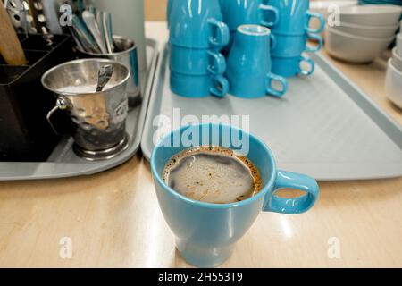 Frisch zubereiteter Instant-Kaffee in der billigen Tasse auf einem Couchtisch mit Tassen, Zuckerdose Stockfoto