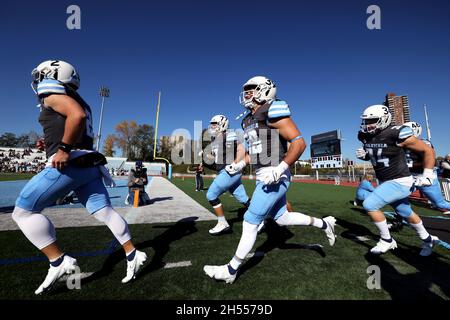 New York City, New York, Usa. November 2021. Mitglieder der Columbia Lions Fußballmannschaft treten heute zu Beginn ihres Spiels gegen die Harvard Crimson auf das Feld im Wien Stadium in New York. Harvard gewann das Spiel 49-21. Quelle: Adam Stoltman/Alamy Live News Stockfoto